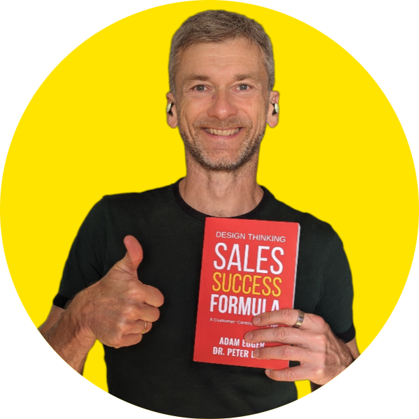 Adam Egger smiling with book, thumbs up on yellow background